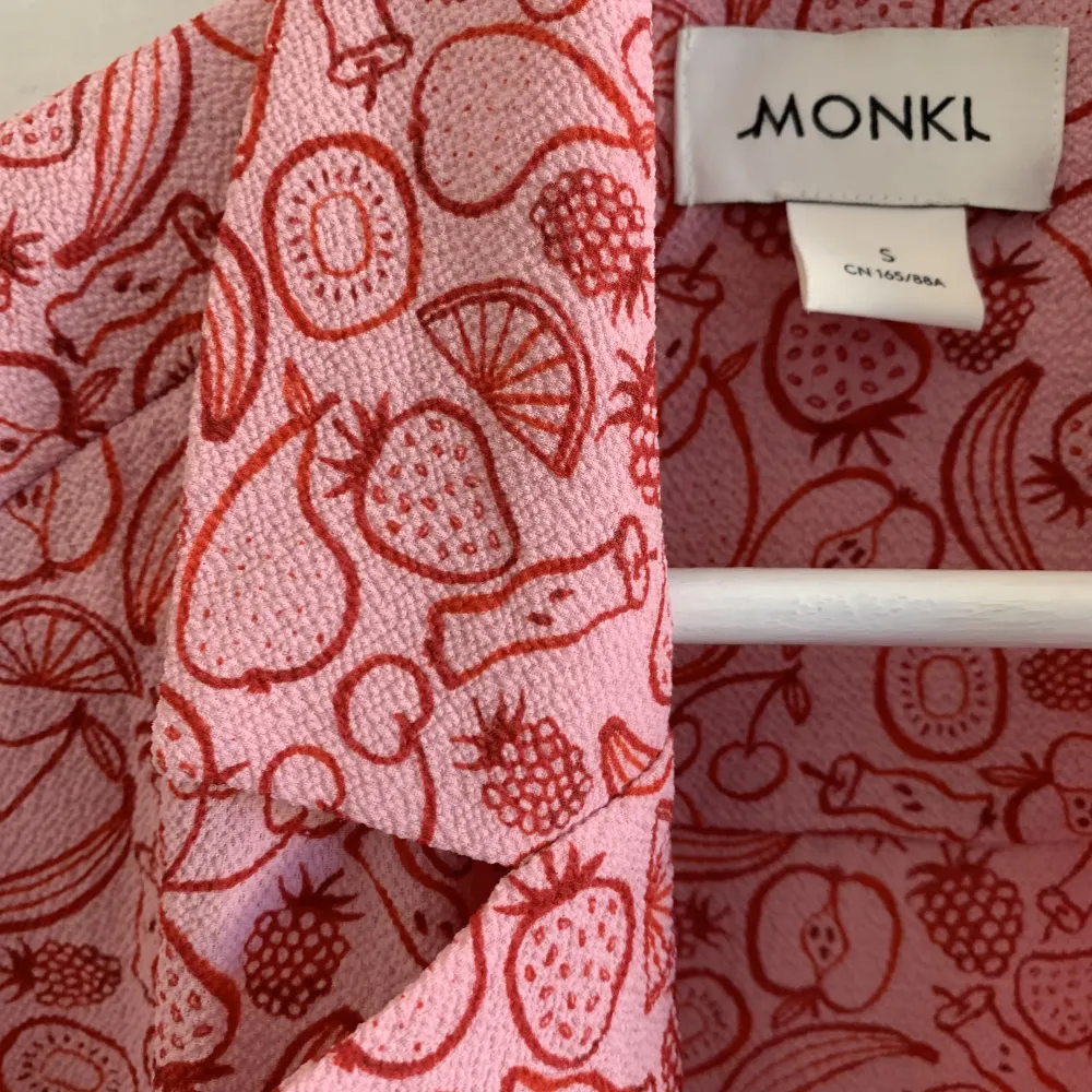 Kortärmad skjorta i rosa och rött med fruktmönster från monki 🍎🍌🍐 fint skick!!. Skjortor.