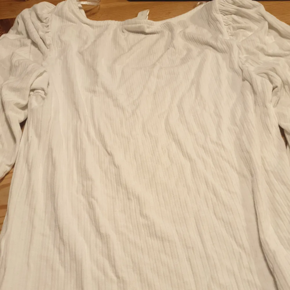 En vit långärmad tröja med lite puffigt på axlarna och den är även lite uringad som man ser. Från HM.. Tröjor & Koftor.