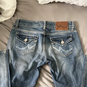 Lågmidjade Jeans med fickor baktill - Lågmidjade jeans med snygga fickor baktill, har en tvättad färg i denim, passar xs, hör av er vid feågor💘