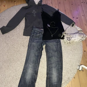 Style bundle  - Skitnygg style bundle innehållande ett par sjuukt snygga Lågmidjade bootcut jeans, ett svart linne med rosetter på, en zip up hoodie med målade kors på, en väska med orm tryck, två armband, ett kors halsband och ett par kedje örhängen. Sjukt snygg outfit