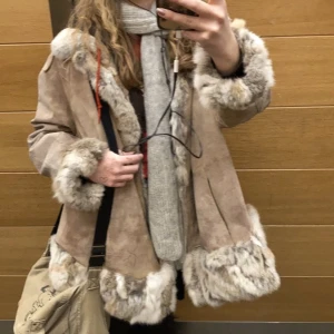 Jacka i päls och mocka - Beige och vit pälsjacka, väldigt fin! Den är stor och rymlig men ser inte klumpig ut när man har på sig den🎀 Den har några små defekter, t.ex. några lösa knappar, men det är inget som synd och lätt att sy. Fluffig och mjuk inuti!