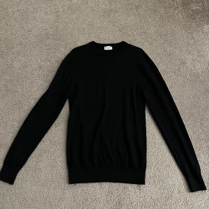 John Henric Svart Tröja 100% Merinoull - Det här är en tunnstickad herrtröja som är stickad i mjuk merinoull med ribbade kanter i storlek S. Den är i väldigt bra skick 9/10 och är endast använd några fåtal gånger. Kan användas året runt! Nypriset ligger på 999kr