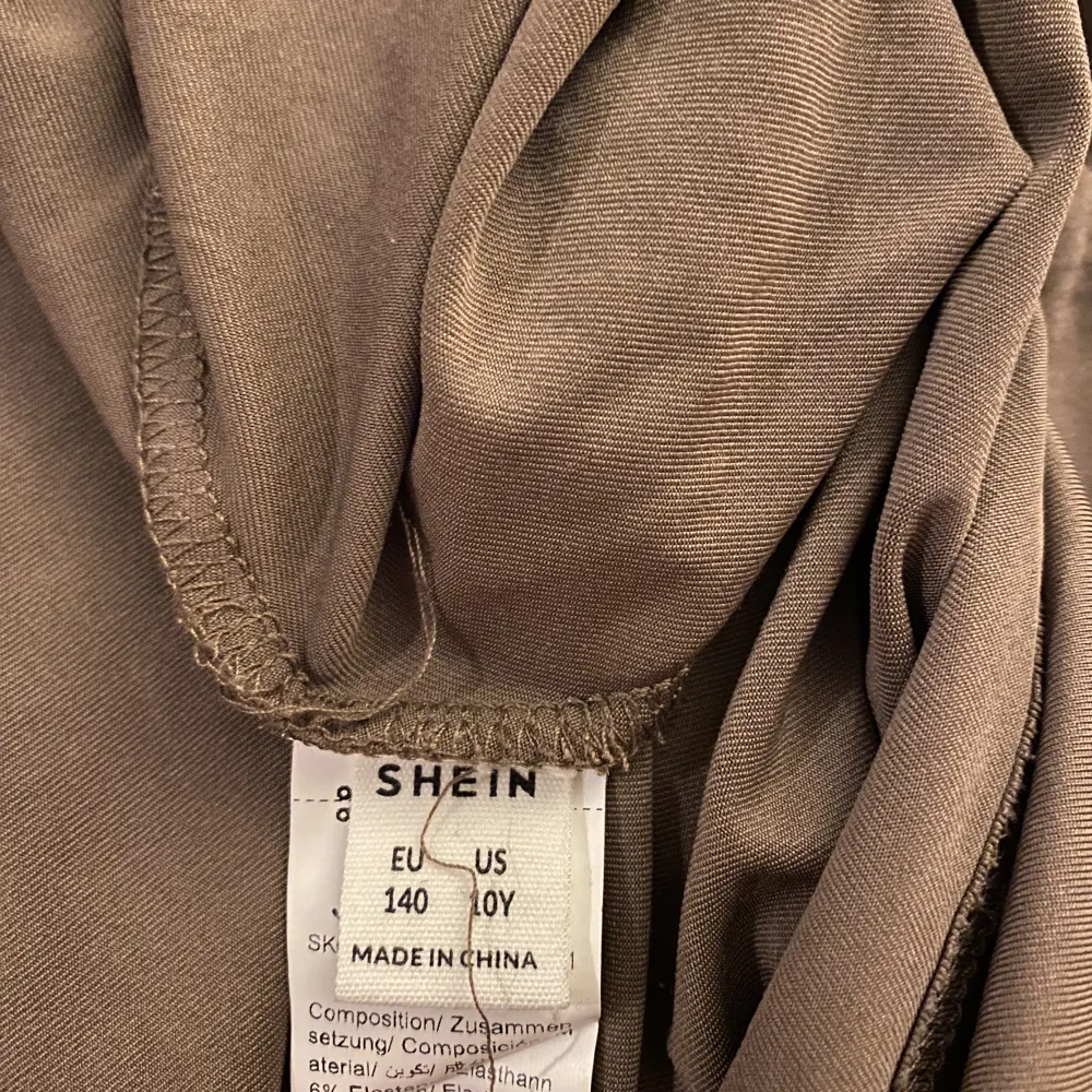 Brun klänning ifrån SHEIN, dne är öppen på sidan av kroppen så den syns, helt oanvänd inga täcken på användning, säljer för 100kr+frakt🤍kom privat för mer, stolek 140. Klänningar.