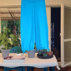 Trekvartsbyxor - Trekvartsbyxor från lingon och blåbär med en liten rosett detalj nere vid bensslutet.   Kan mötas i Eskilstuna eller skickas på posten.