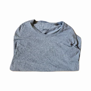 Hugo Boss T-Shirt - Grå Hugo Boss T-shirt i storlek S. Den är väl använd, skick 7/10. Nypris 399kr.