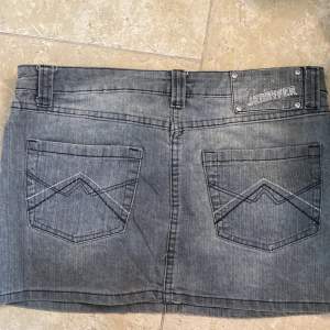 grå lågmidjad mini jeanskjol i nyskick. Så fin och har detaljer på fickorna. Står ingen storlek men skulle uppskatta 38💓 midjemått:70