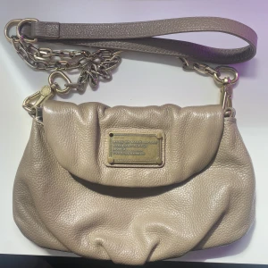 Marc jacobs väska  - Så fin beige Marc jacobs crossbody väska, fint skick förutom att en ”skruv” har lossnat på brickan vilket syns tydligt på första bilden💗 Postas eller möta upp i Göteborg!