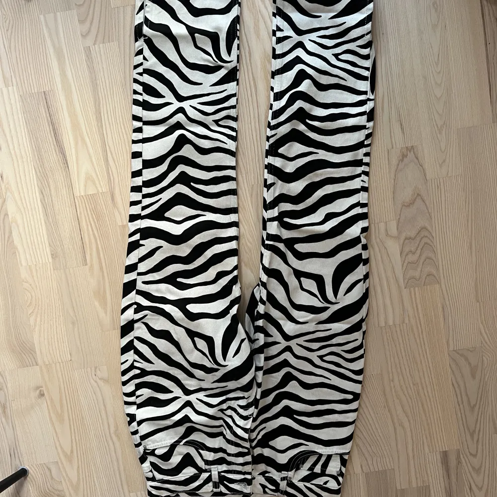 Säljer ett par jeans i zebramönster från Nelly i storlek 36! Fina med en slits längst ner. Helt slutsålda på hemsidan! Säljer för 150kr 🫶🏽🫶🏽. Jeans & Byxor.