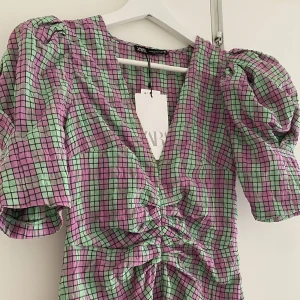 Oanvänd klänning - Riktigt snygg klänning från Zara, helt oanvänd! Figursydd runt midjan, puffärm och v-ringning. Nypris: 559kr 