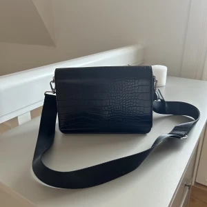 Axelremsväska  - En rymlig axelremsväska från GinaTricot med krokodil liknande mönster✨