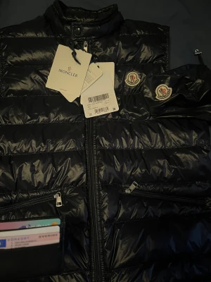 Moncler gui väst - Navy Moncler gui vest Stl 4 Cond: 9,5/10 (flawless) (självklart äkta).  Tags samt dustbag medföljer. Kan möjligtvis gå med på byten. Fler bilder skickas i pm!
