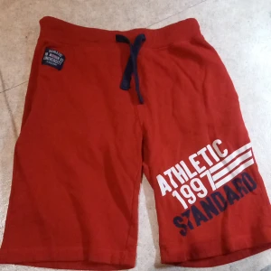 Fräsiga shorts - Fräna röd shirt perfekt för yngre Smått slitet baktill Skriv om frågor eller funderingar uppstår