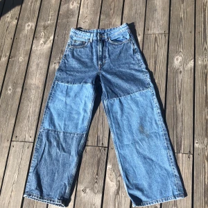 Blå Färgblock jeans - Ett par bagge jeans från Monki med mörk och ljusblåa ”block” på. Orginelt köpta för 400kr. Har en liten fläck på ena knät (visad på andra bilden) använda några gånger. Säljer då dem inte är min stil längre och är lite små