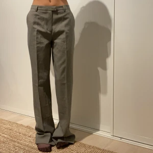 Kostymbyxor - Ett par gråa, lågmidjade kostymbyxor. Säljer då de blivit aningen förstora för mig. Jag bär vanligtvis strl 32/34 i byxor och skulle säga att dessa är en 34/36:a. Jag är 166 cm ❤️