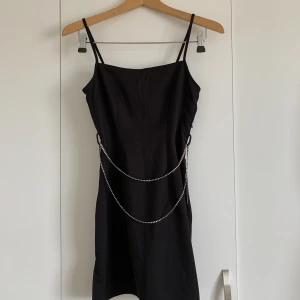 Svart klänning - Svart mini klänning i st S från H&M, använd endast en gång. Den är tajt upptill men lite mer utsvängd som en ”kjol” nedtill och ett bälte som skiljer dem åt. 
