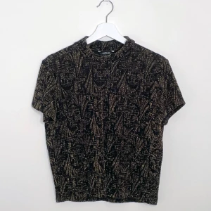 Glittrigt topp  - Guldglittrig topp med halvpolo från Monki i storlek L  Använd fåtal gånger 💛