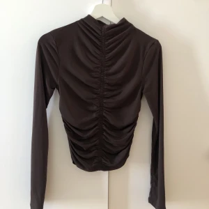 Fest topp - Superfin mörkbrun ”fest topp” rynkad i mitten som gör att det är SÅ FIN passform!
