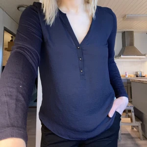 Marinblå blus med guldknappar - H&M - Snygg långärmad marinblå blus med guldknappar. Endast använd några få gånger.