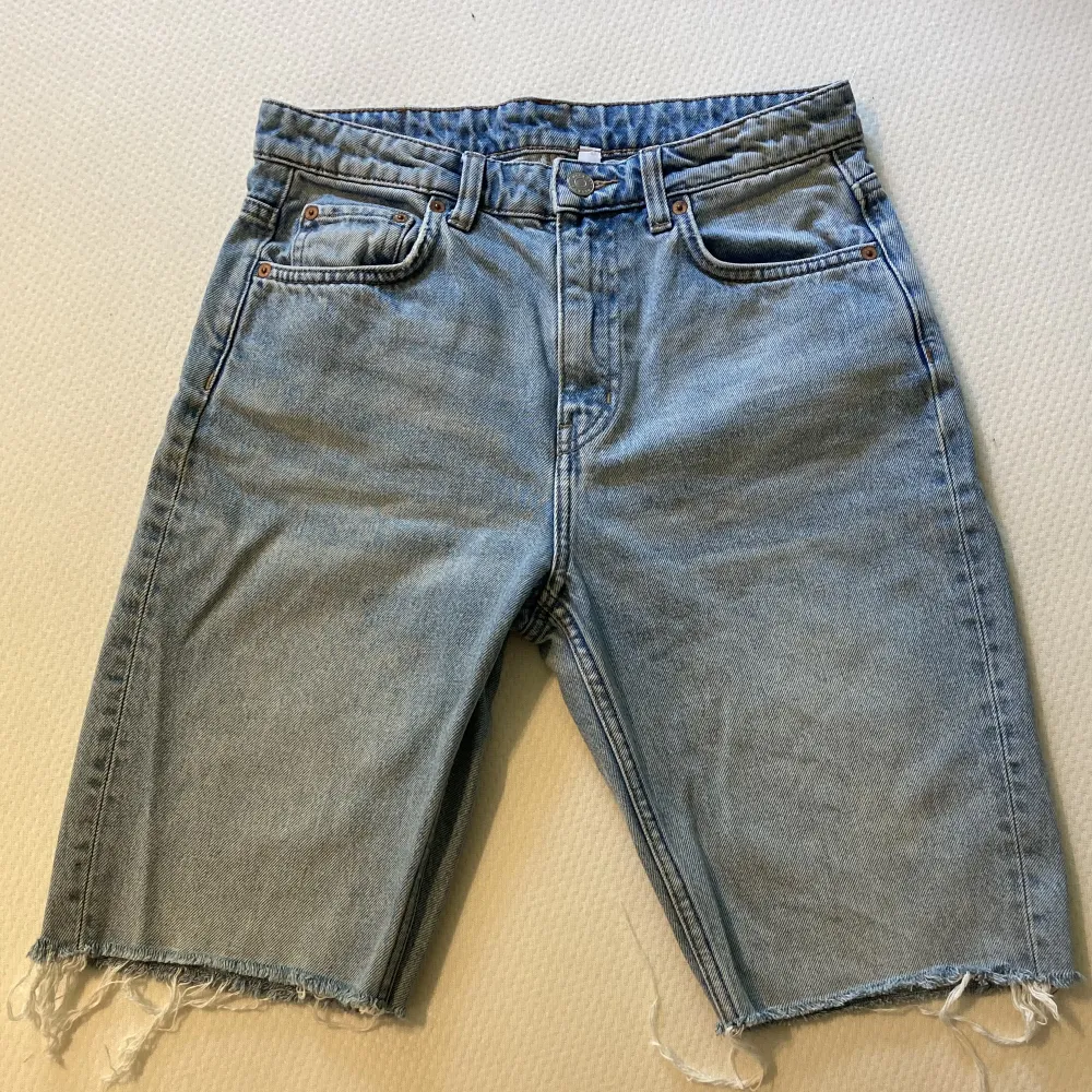 Byxor från Weekday, ”seattle week blue”, avklippta till shorts. Fransiga i ändarna. Storlek i midjan: 26. Välanvända med en del små synliga slitningar.. Shorts.