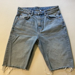 Jeans shorts - Byxor från Weekday, ”seattle week blue”, avklippta till shorts. Fransiga i ändarna. Storlek i midjan: 26. Välanvända med en del små synliga slitningar.