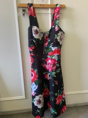 Blommig klänning  - En svart klänning med blommor. Den har även en slags bh i sig.