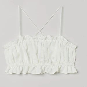 Croppat linne i linmix - Köpt från H&M, aldrig använt enbart testat.  Jättefint material, viskos/lin, volang upptill och i nederkant, öppen rygg, banden korsas och knyts i ryggen.