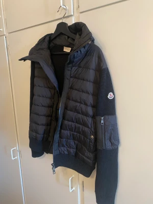 Moncler Cardigan - Säljer en helt ny Moncler jacka då den inte kommit till användning. Storleken passar både S och M beroende på hur du vill den ska sitta på.