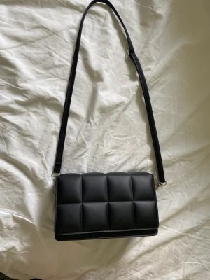 Svart handväska Dam - Denna väska är så smidig att ha med sig då den är ganska liten men du får absolut plats med mycket i den ändå! Den är bara använd några få gånger så den är i exakt lika bra dock som när jag köpte den! Frakt står kunden för