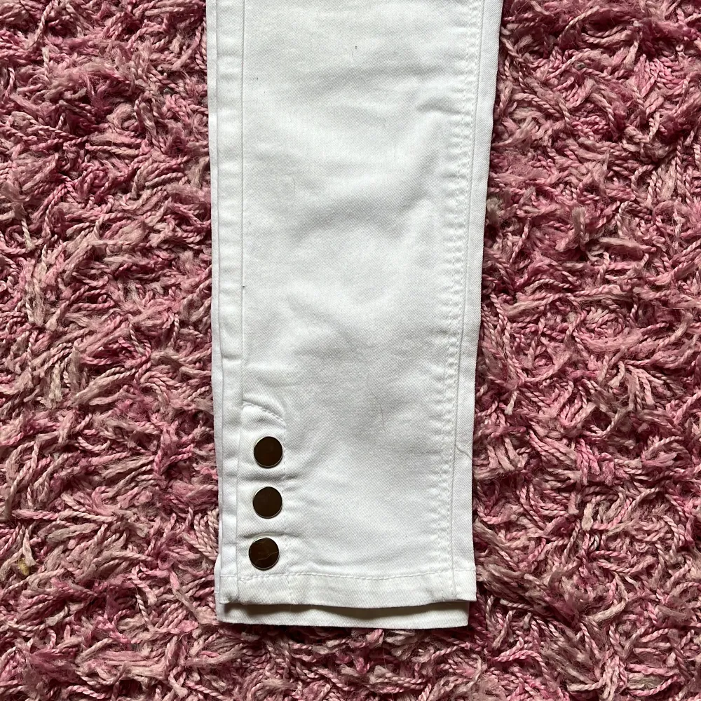 Det är stretchiga anklelånga skinnyjeans med knappar längst ner på byxbenet . Jeans & Byxor.