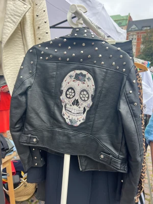 Skinnjacka - Svart skinnjacka med nitar och mönster. Storlek M, fint skick. 