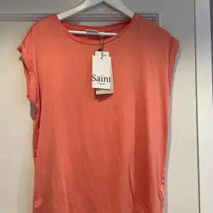 En aprikos rosa t-shirt som är helt oanvänd från Saint Tropez  i storlek M. Den är köpt från åhlens. Köpte den för 299 och säljer den 150 kr + frakt. 