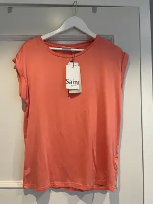 En aprikos rosa t-shirt som är helt oanvänd från Saint Tropez  i storlek M. Den är köpt från åhlens. Köpte den för 299 och säljer den 150 kr + frakt. 