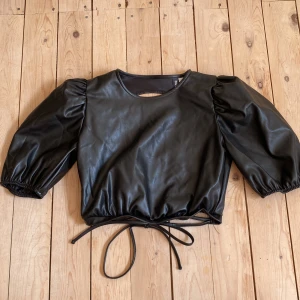 Skinntopp  - Skinntopp från HM med knyte i ryggen. Använd en gång, finns liten defekt på snöret (se bild). 