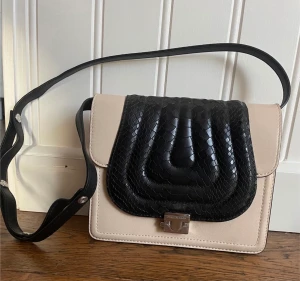 By Malene birger - Snygg väska från Malene Birger i äkta skinn,  21 cm x 16.5 cm  Låset är tyvärr defekt.