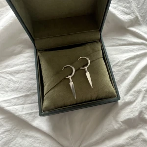 Maria Nilsdotter!! - Säljer dessa sjukt snygga Maria Nilsdotter örhängen. Köptes i början av förra sommaren. Ena örhänget har en super liten defekt! Skriv för fler bilder! Ny pris 4200kr för båda!🥰 KOM MED PRISFÖRSLAG!! (Min mobil som reflekterar mot örhänget, inte smuts)