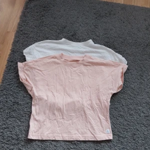 Oversize korta tshirts - 2 st en i rosa och en i vit oversize korta tshirts. Dem har aldrig används men har två små håll där bak där lappen sitter. Se bild. Den händige kan säkert fixa det med en ögonblickning.   Köpta på lager157.  Storlek 150 Betalning via swish. Se fraktkostn