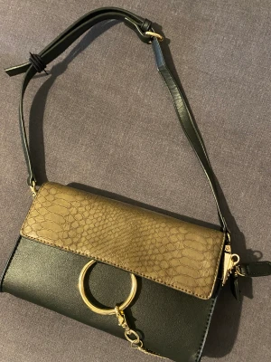 Handväska  - En handväska som iprincip är helt ny, endast använd ett fåtal gånger. 