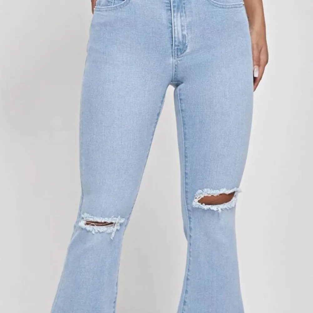 Ett par blåa utsvängda jeans med små hål. Helt nytt skick,super fina och sitter perfekt . Jeans & Byxor.