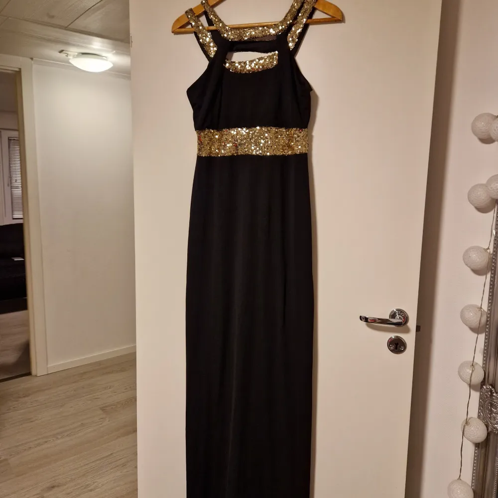 Superfin helt ny långklänning som jag säljer då den inte kommer till användning. klänningen är svart med guldpaljetter som är perfekt till balen. Strl L.. Klänningar.