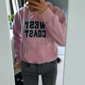 Hoodie - Rosa Hoodie med tryck. Jag säljer den för att den har blivt lite för liten och inte sitter bekvämt på grund av det. Det står att storleken är M men den passar mer som en XS. Köparen står för frakten!