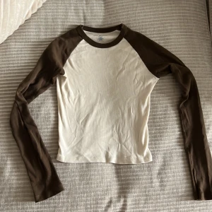 Långärmad Tröja  - En beige långärmad tröja med bruna ärmar från Brandy Melville💓  Står ingen storlek men väldigt stretchigt material så kan funka på de flesta beroende på vilken fit man gillar🥰 Använd några gånger hemma. Priset inkluderar inte frakten💓