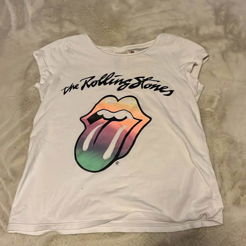 En jätteskön Rolling Stones T-shirt. Bra skick och knappt använd. Baksidan är helt vit. Den är storlek 134/140☺️Köpt på H&M. Priset kan diskuteras😇✨. T-shirts.