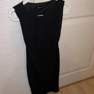 Klänning - En vanligt kort tight klänning från Nelly. Lite öppen vid sidorna av brösten. Storlek XS