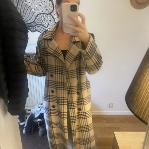 Trenchcoat från NA-KD  - Säljer mina fina trenchcoat från NA-KD. Skulle säga att jackan är en blandning av en trenchcoat och kappa och går att använda långt in på hösten!   Kappan köptes för två årsedan för 1099kr men är i sparsamt skick!🫶 