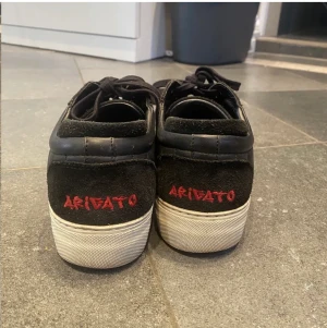 Axel Arigato - Svarta arigato skor med cool röd logga där bak! Storlek 40 men passar 39🔥