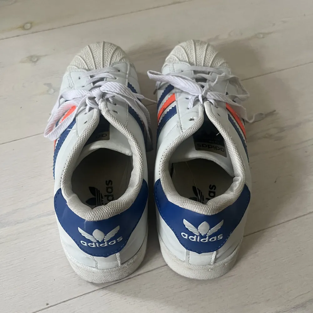 Adidas skor med blå och orangea ränder. Använda ett fåtal gånger💙🧡. Skor.