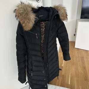 Hollies jacka  - Den har några år på sig så lite slitage finns, annars väldigt varm och fin dunjacka.