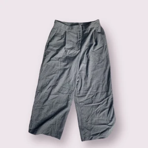 Vida kostymbyxor - Fina gråa vida kostymbyxor. Lite kortare i längden. Fint skick utan några defekter.