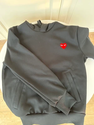 CDG Hoodie  - Säljer min Cdg ”Comme des Garçons PLAY” hoodie i svart. Använd några gånger men känner att jag ångrat mitt köp. Väldigt bra skick, inga skador eller fel. Skick 8/10