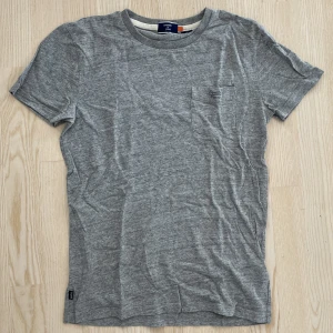 Grå T-shirt från Superdry, stl S - Grå T-shirt från Superdry i stl S. Använd i bra skick. 100% bomull. Skriv gärna för fler bilder✨